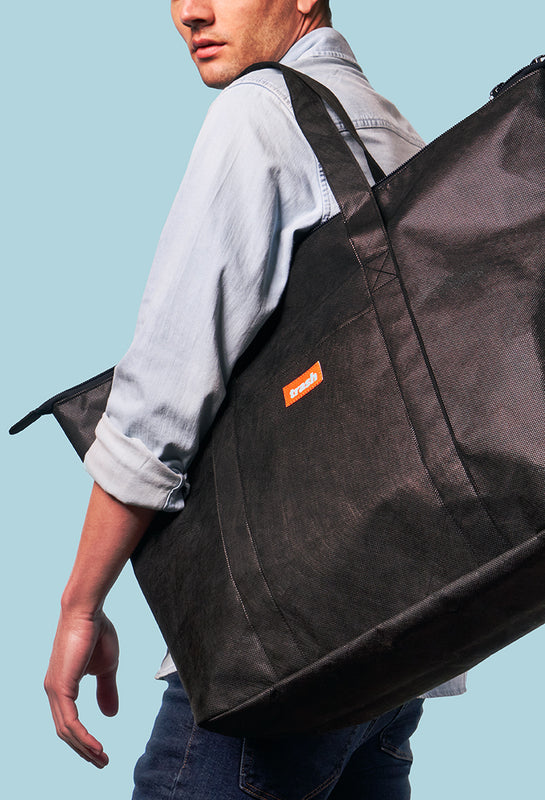 Man carrying black recycled weekender bag