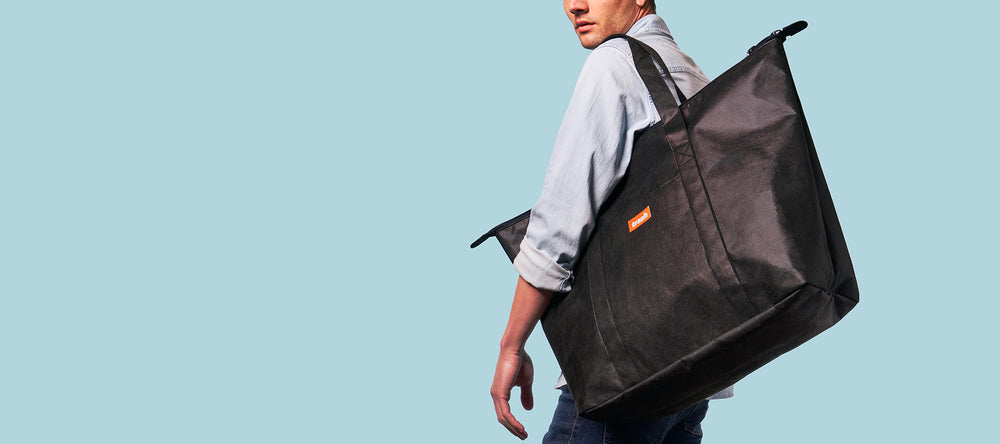 Man carrying black recycled weekender bag