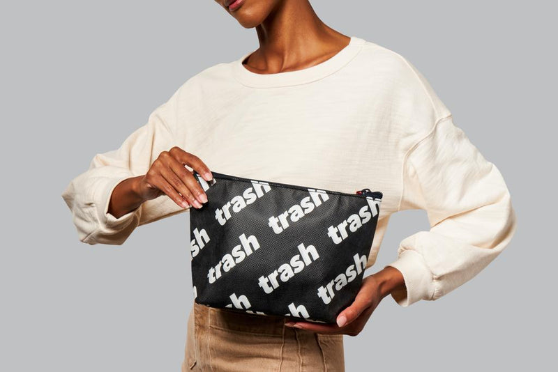Holding toiletry bag with Trash Print